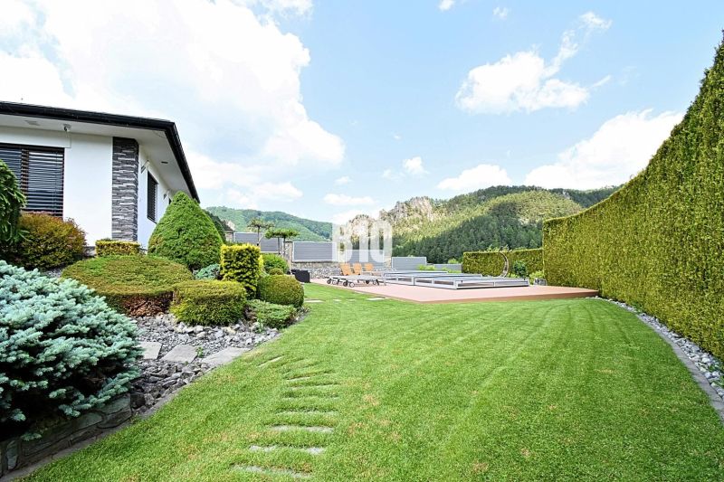The garden of a family house in Súľov-Hradná with a swimming pool and well-maintained lawn.