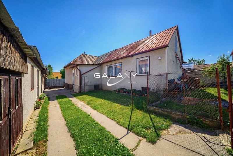 A family house in Stará Bašta with a lawn and a fenced garden.