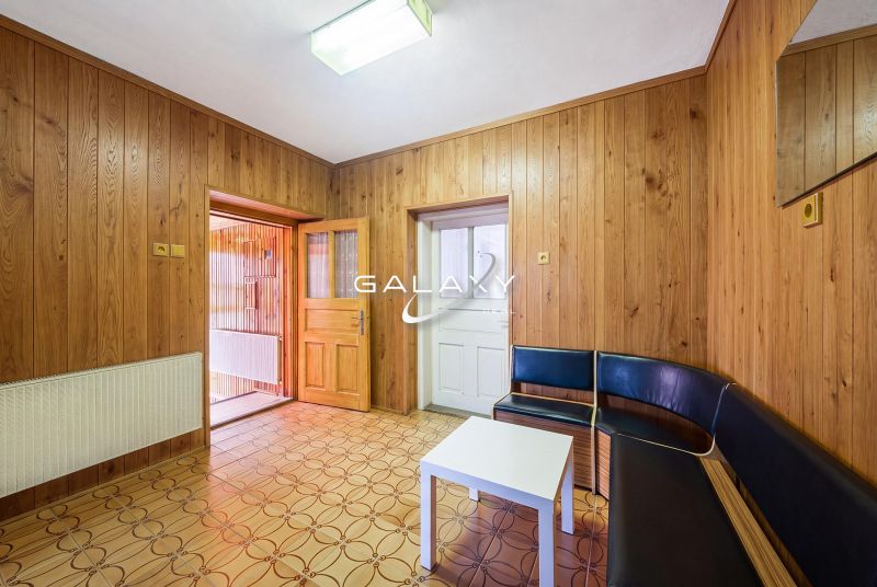 Wooden wall cladding and geometric flooring in the interior of a family house.