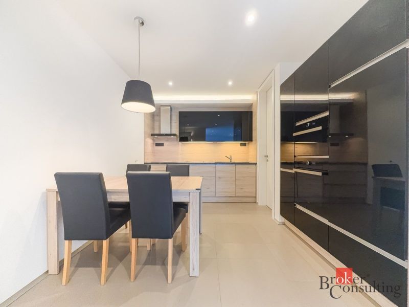 Kitchen area in a 2-room apartment with a dining table and kitchen unit.