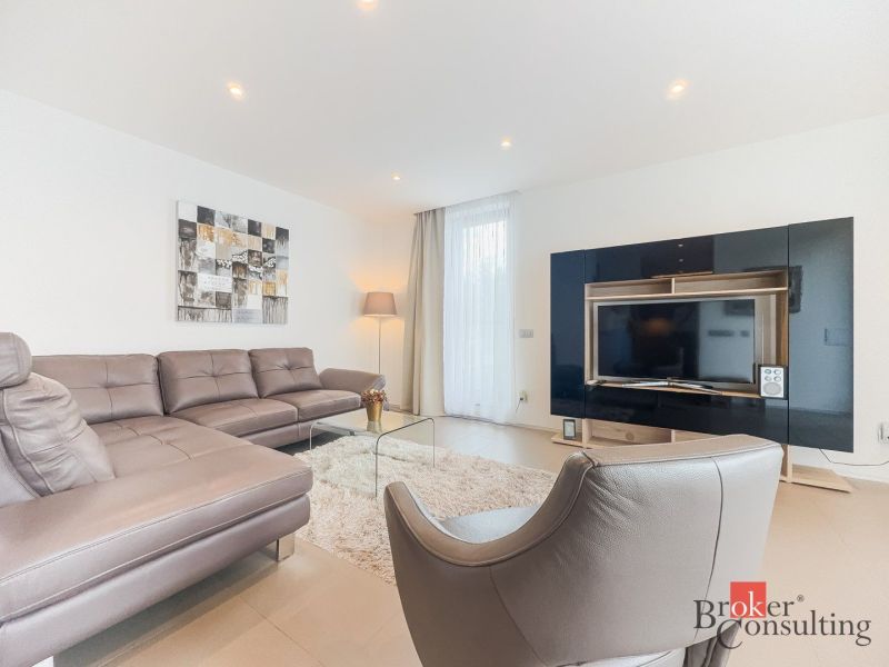 Living room with a black TV cabinet, sofa, and armchair in a two-room apartment.
