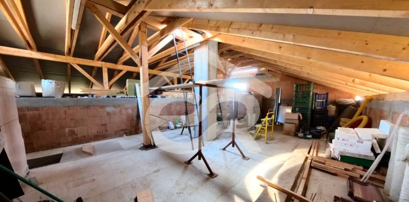 The attic of a family house with wooden beams and construction materials in the interior.