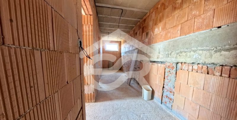 Interior walls in a brick family house under construction with a concrete ceiling.