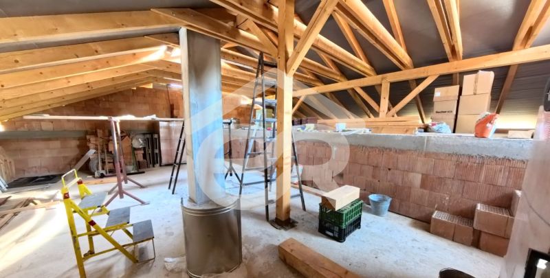 The attic of a family house under construction with wooden beams and building materials.