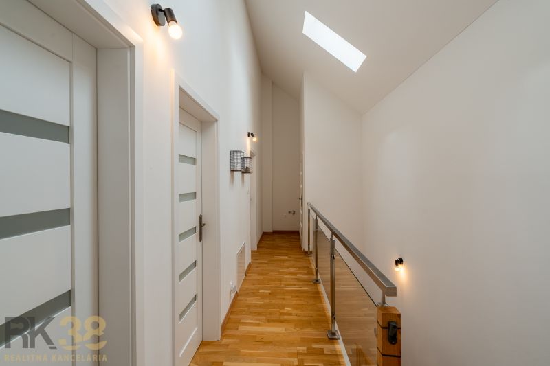 A hallway in a 4-room apartment with a wooden decor floor and a skylight.