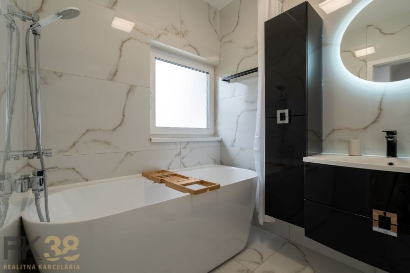 A bathroom with a shower, bathtub, and marble tiles in a 4-room apartment.