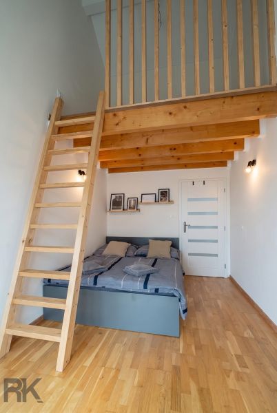 Bedroom in a 4-room apartment with a gallery and a wooden decor floor.