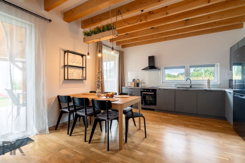 A kitchen in a 4-room apartment with a dining table and a wooden-patterned floor.