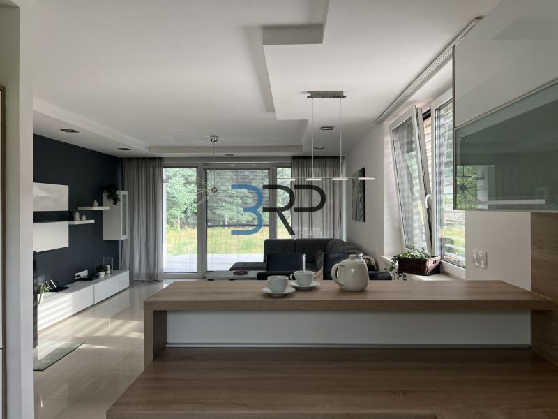 Living room in a family house with a sofa, glass doors, and modern furniture.