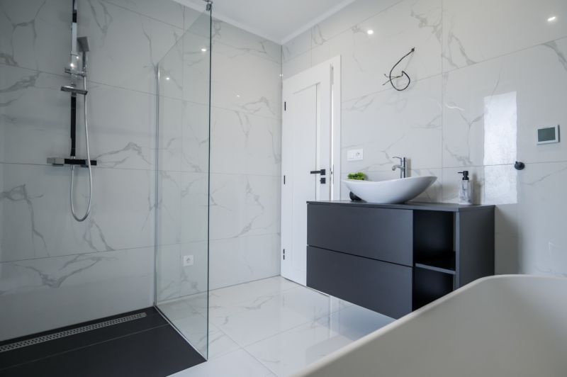 A bathroom in a family house with a glass shower enclosure and white ceramics.