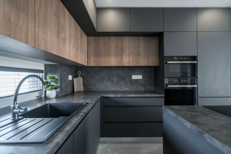 A kitchen in a family house with dark cabinets and a wood-patterned floor.