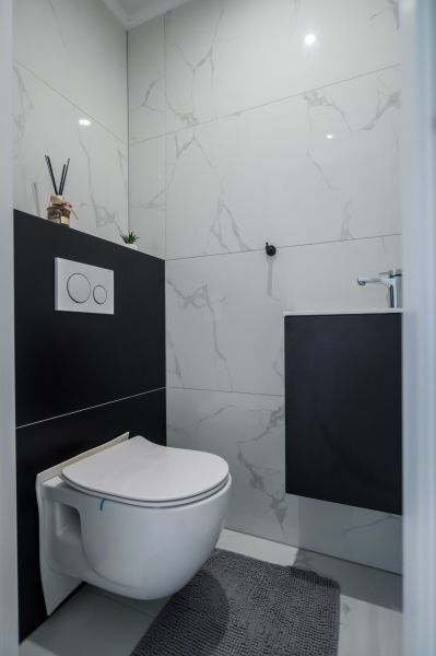 Bathroom in a family house with tiles and a concealed toilet.