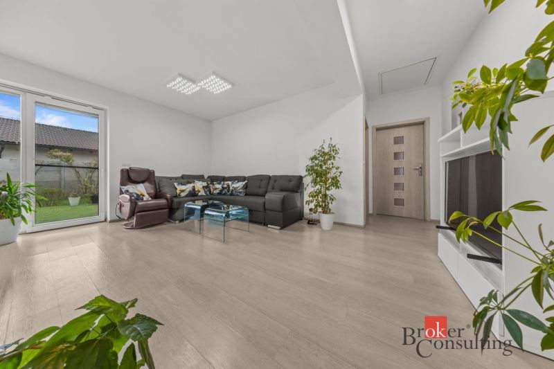 Living room with a comfortable sofa in a family house, floor with wooden decor.