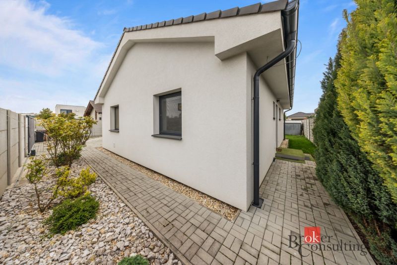 A family house in Bratislava-Podunajské Biskupice with a paved walkway and a landscaped garden.