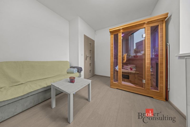 A room in a family house with an infrared sauna and a sofa, floor with wooden decor.