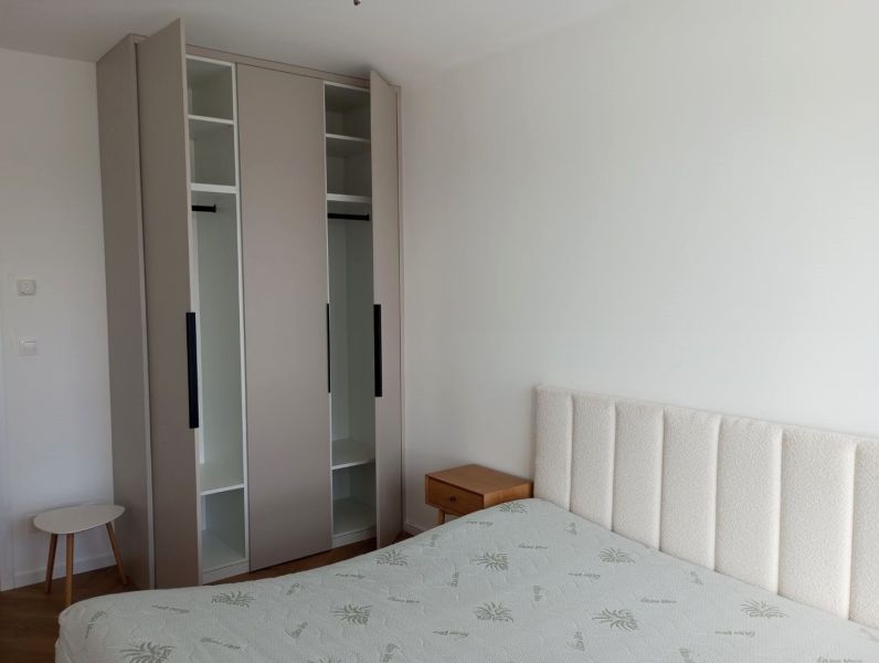 Bedroom in a 2-room apartment with a bed, wardrobe, and nightstand.