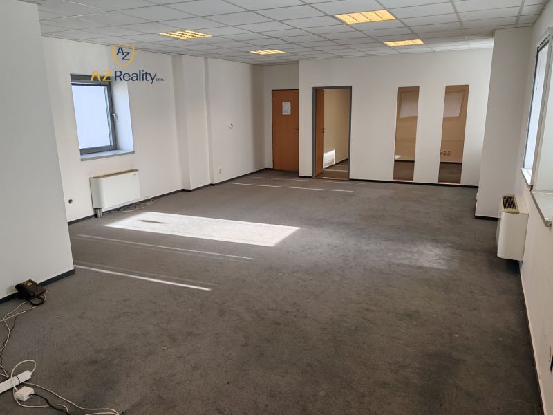 Offices with carpeted floors, white walls, and windows without curtains.