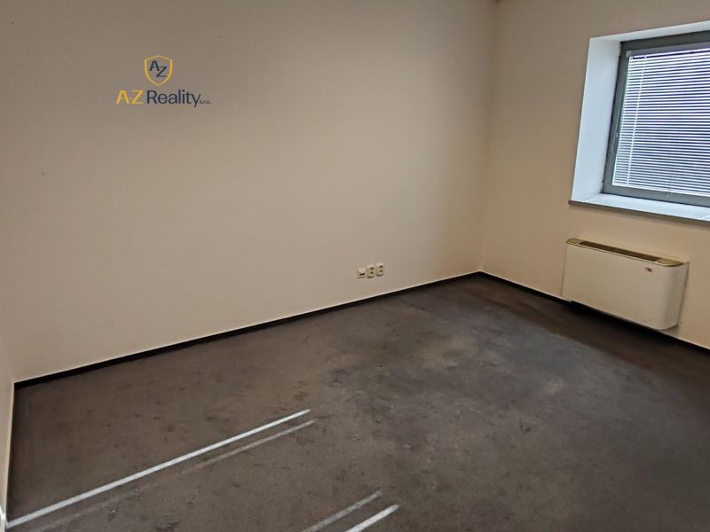 Room with carpet, white walls, and a window with blinds in an office.