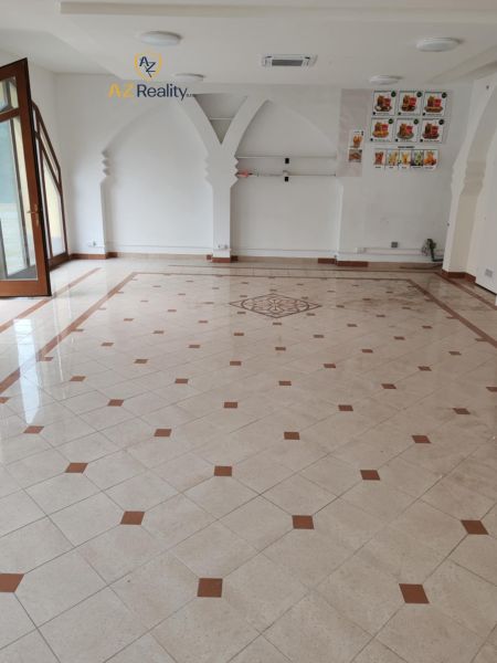 Empty commercial spaces with mosaic flooring and arched wall decor.