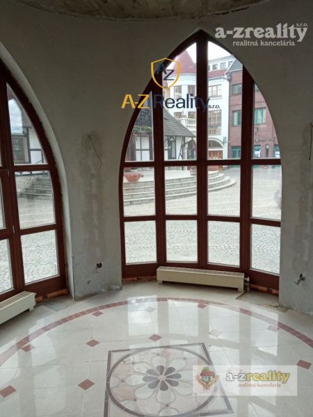 Commercial premises with large arched windows and mosaic flooring, overlooking the Courtyard of Europe in Komárno.