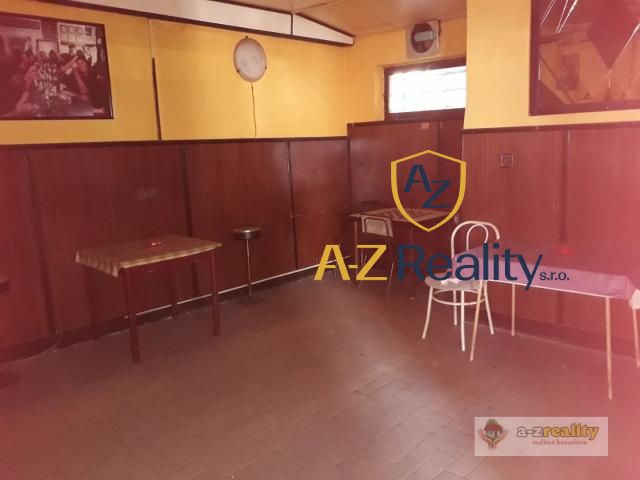 The interior of the building with wood-decor flooring, tables, and chairs.