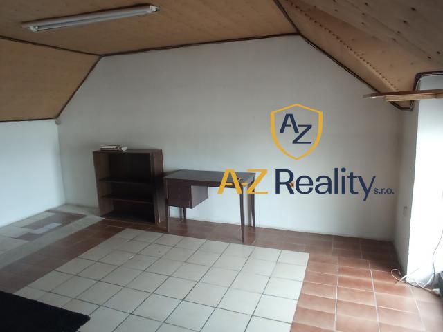 Interior of a building with a window, table, and wooden ceiling.