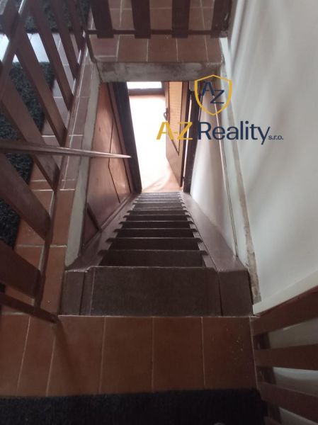 A staircase leading down with a brown floor in the building.