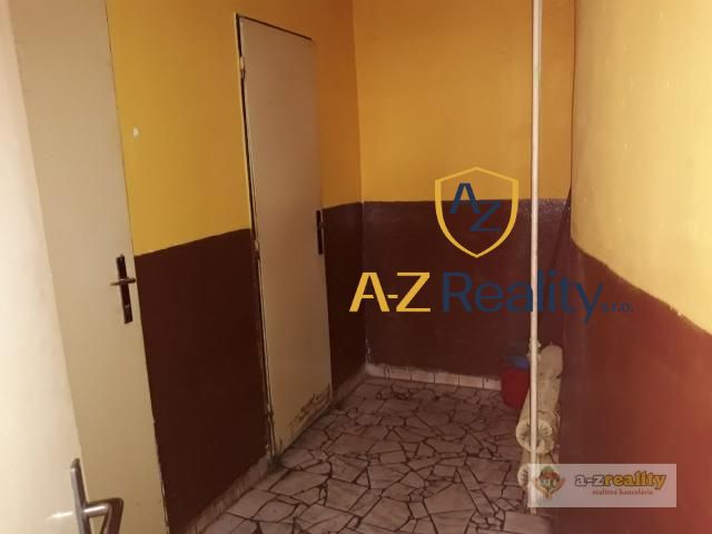 The interior of the building with a mosaic floor and brown-yellow walls.