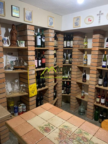 A wine cellar with brick shelves in a family house, full of wine bottles and decorations.