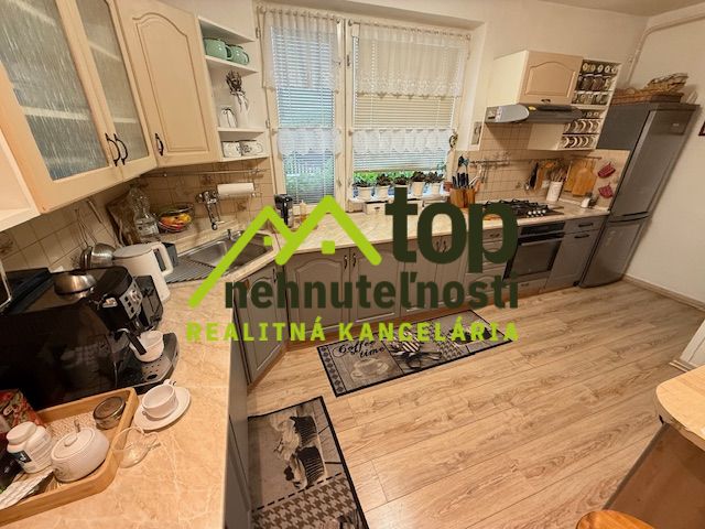 A kitchen in a family house with a wooden decor floor and kitchen equipment.