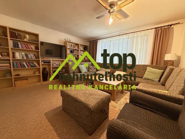 Living room in a family house with a comfortable sofa, bookshelf, and television.
