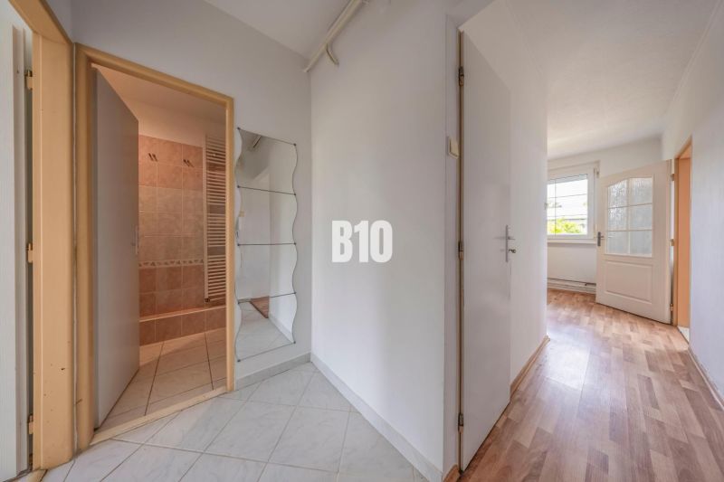 Entrance hallway in a 2-room apartment with a wooden decor floor and a bathroom.