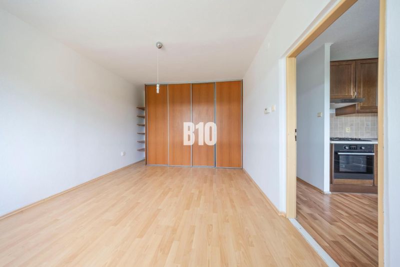 Interior of a 2-room apartment with a wooden decor floor and a built-in wardrobe.