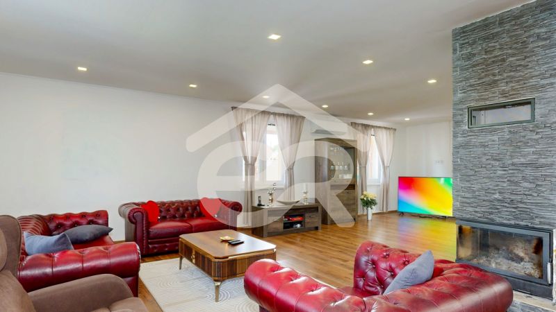 Living room in a family house with a fireplace, color TV, and a floor with a wooden decor.