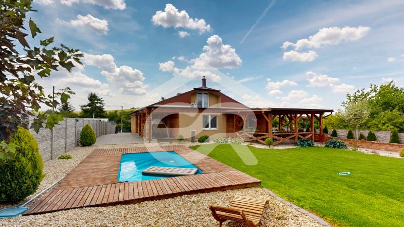 A family house on Lehota Street in Lehota with a pool and a terrace surrounded by a green lawn.