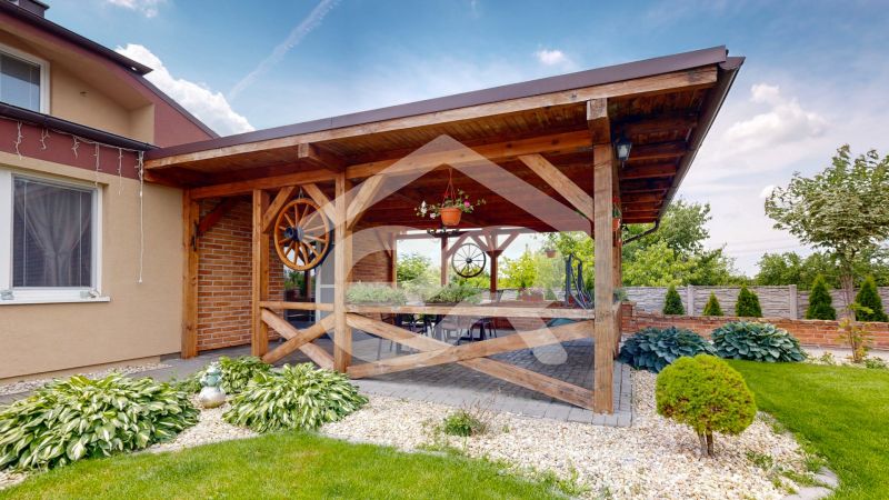 A terrace with a wooden pergola and a garden in Lehoty by a family house.