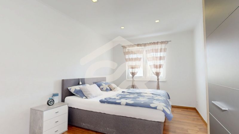 Bedroom with a double bed, a nightstand, and a large window, Family house.