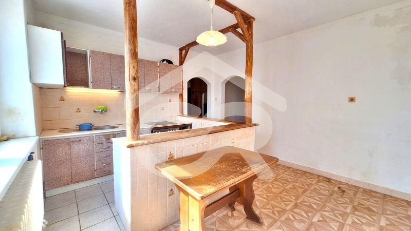 A kitchen in a family house with wooden elements and a floor with a wooden decor.
