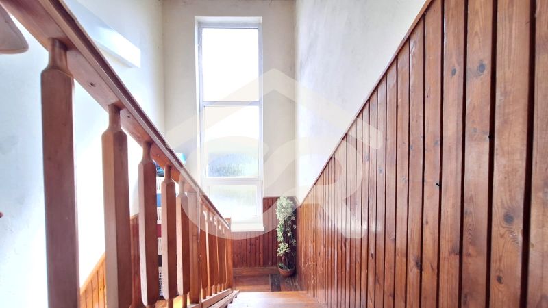 A staircase with a railing and wooden paneling in a family house.
