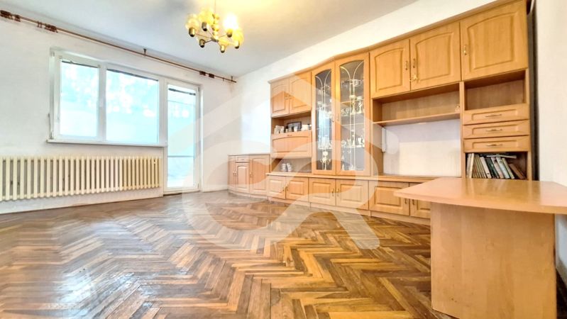 Living room with wood-patterned flooring and furniture in a family house.