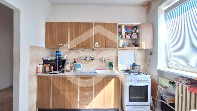 A kitchen in a family house with a gas stove and cabinets with a wood decor.
