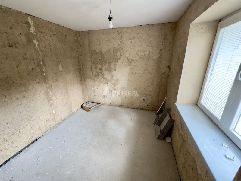 A room with bare walls and a concrete floor in a family house.