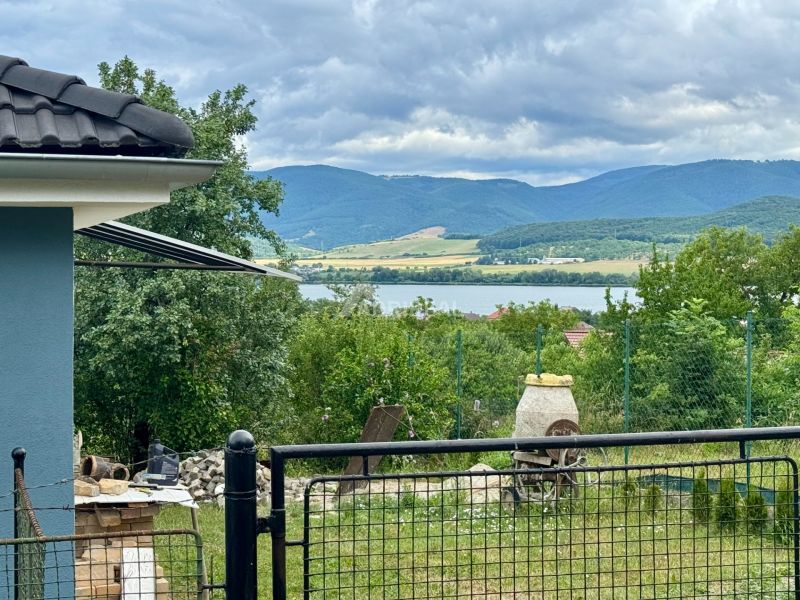 View from a family house in Ružiná of the lake, trees, and hills.