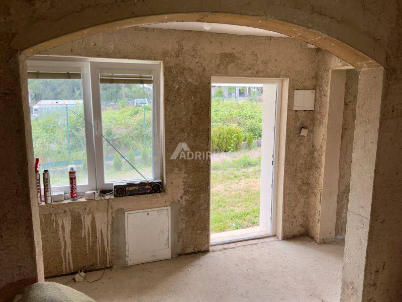 Interior of a family house with a view of the yard through open doors.