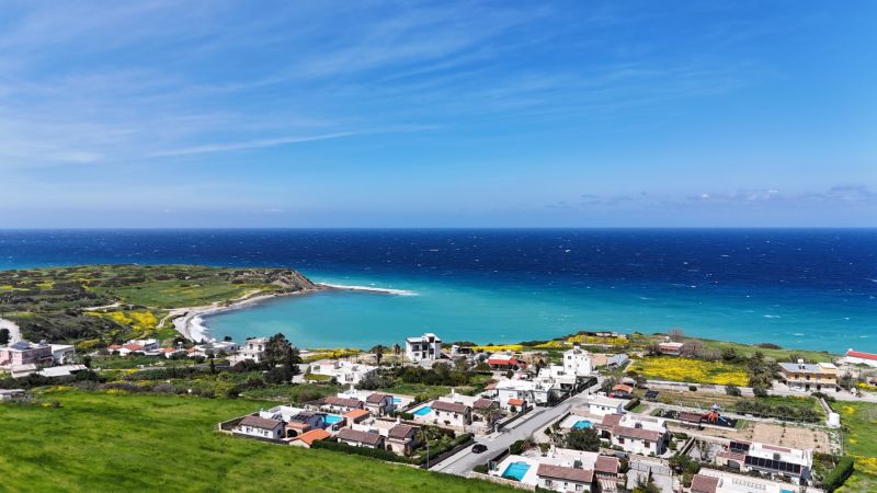 The coast of Agia Eirini with a view of the blue sea and green surroundings.
