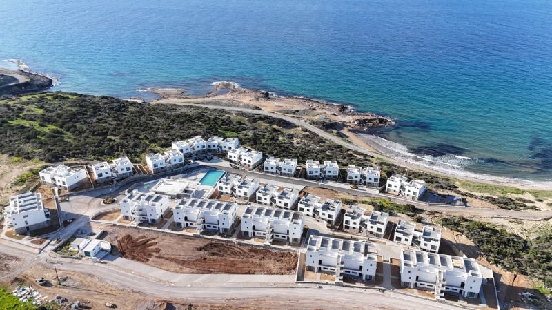 View of the coastal residential area in Agia Eirini with seaside apartments.
