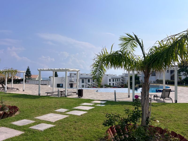Garden and pool at a 2-room apartment in the city of Agia Eirini with a green lawn.
