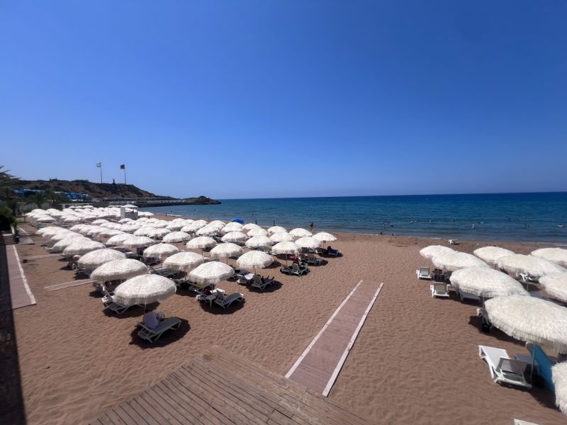 Sandy beach with sunbeds and umbrellas by the sea in Agia Eirini.