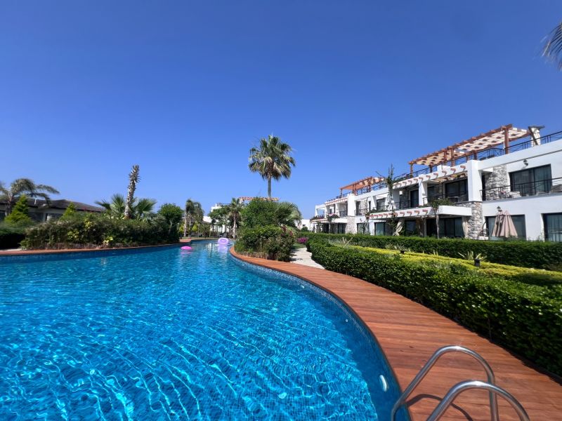 The pool and garden at the 2-bedroom apartments in the town of Agia Eirini on a sunny day.