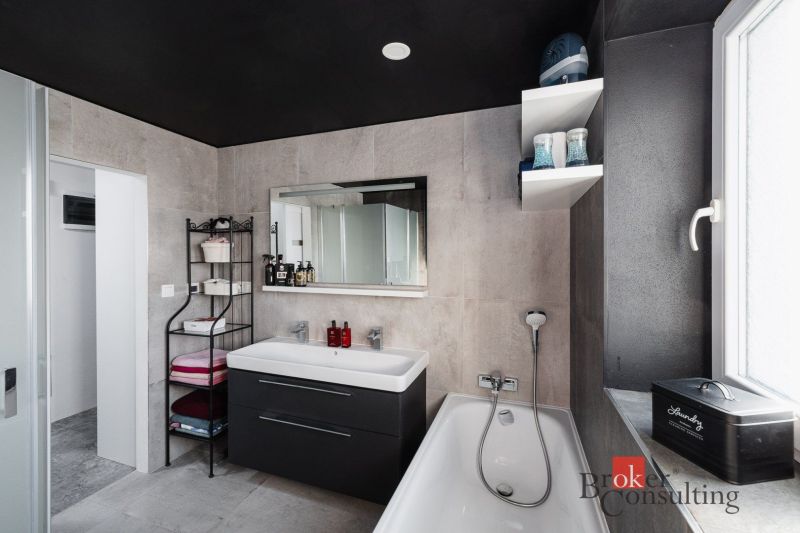 Bathroom in a 2-room apartment with a bathtub, sink, and storage space.